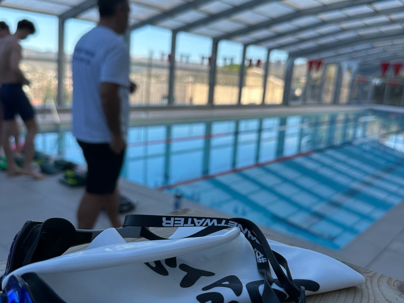 Un coach Stage 21 avec de jeunes nageurs au bord du bassin